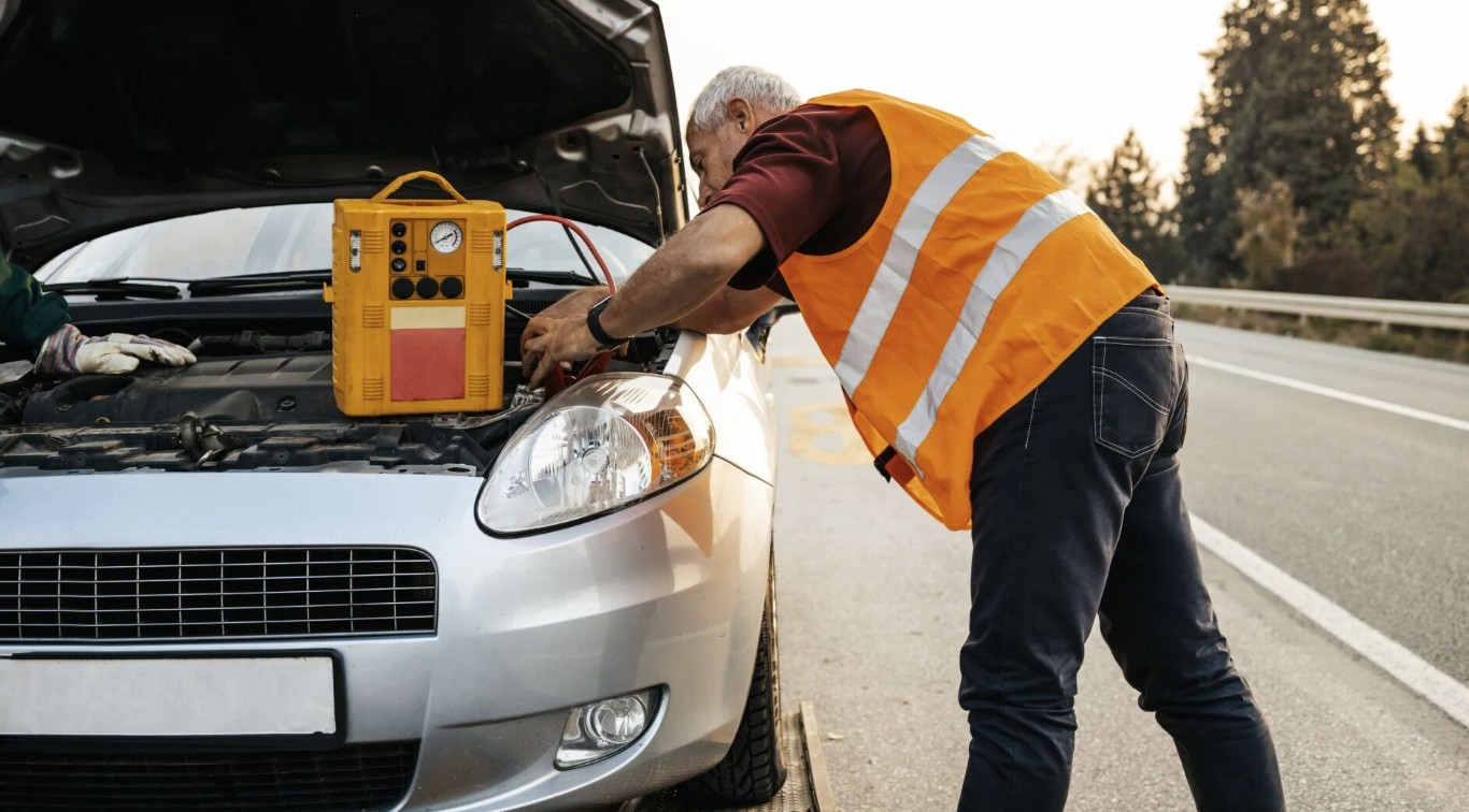 Roadside assistance technician helping stranded motorist with vehicle repair in Beavercreek, OH