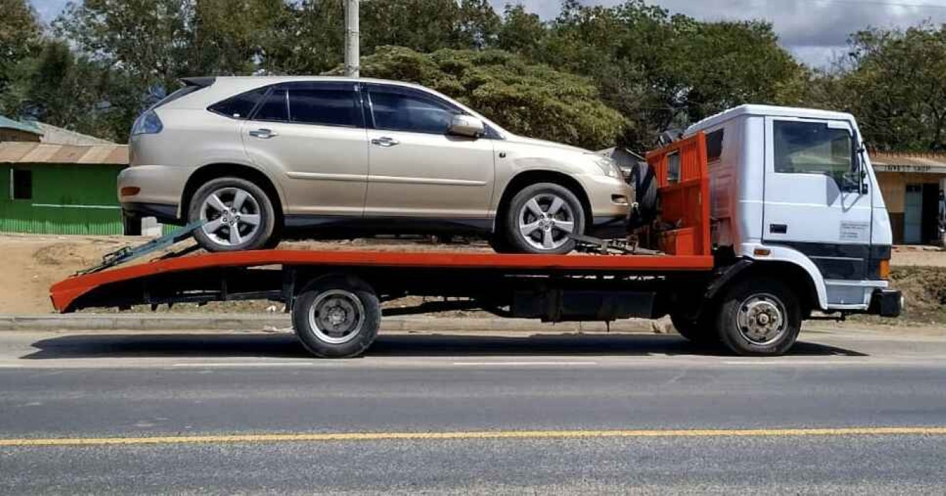 Long-distance towing service transporting SUV on flatbed tow truck