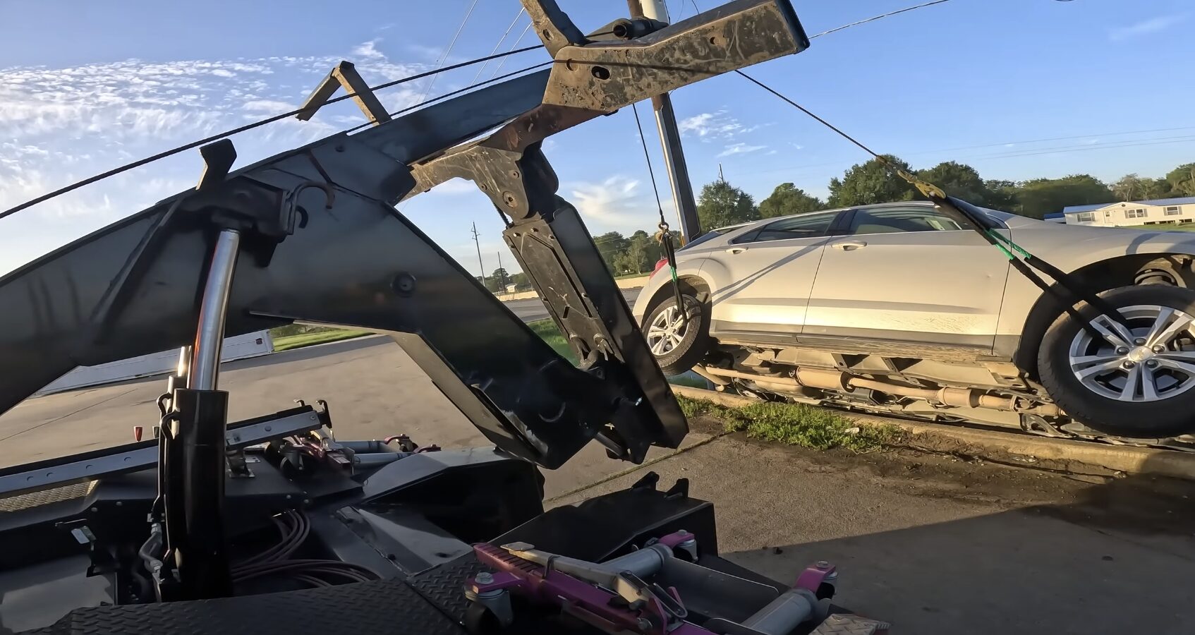 Car Towing Service - Professional vehicle loading and transport by Beavercreek Towing Professional tow truck operator loading a damaged sedan onto flatbed for safe transport