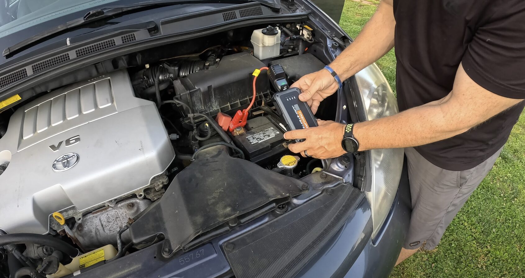 Roadside Assistance - Battery jump-start service by Beavercreek Towing Technician jump-starting car battery with professional roadside assistance equipment